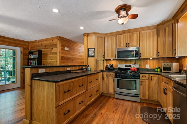 823 Turtle Creek Rd, Sylva, NC 28779 - kitchen featuring stainless steel appliances, a peninsula, a textured ceiling, dark wood-type flooring, and dark countertops