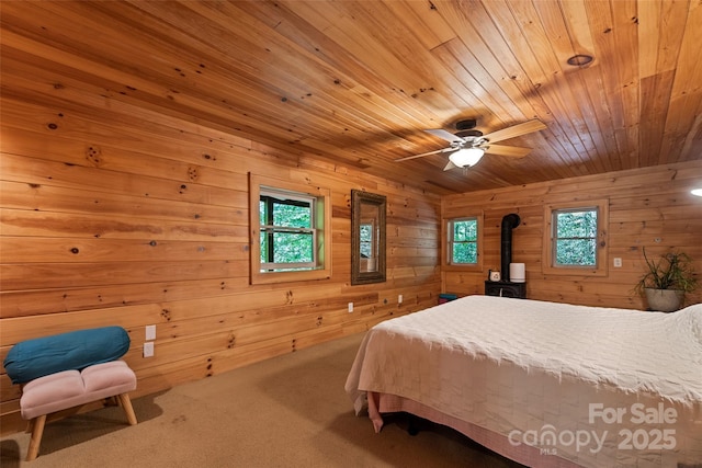 823 Turtle Creek Rd, Sylva, NC 28779 - carpeted bedroom featuring wooden ceiling, wood walls, a wood stove, and a ceiling fan