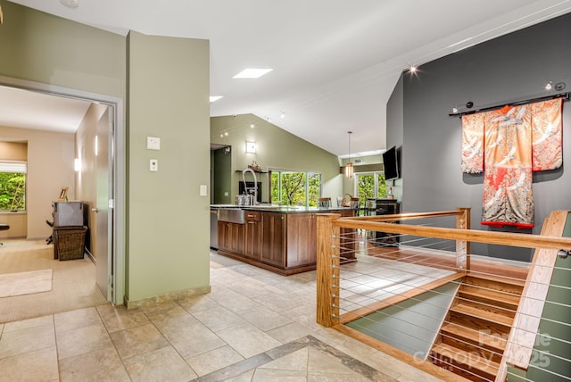 1760 Winding Creek Dr, Waynesville, NC 28786 - kitchen with healthy amount of natural light, lofted ceiling, brown cabinets, pendant lighting, and an island with sink
