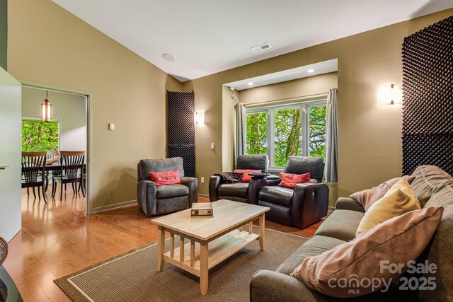 1760 Winding Creek Dr, Waynesville, NC 28786 - living room with plenty of natural light, wood finished floors, baseboards, and vaulted ceiling