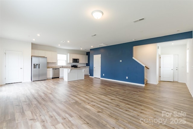 3073 Langhorne Ave SW, Concord, NC 28027 - unfurnished living room featuring light wood-style flooring, recessed lighting, baseboards, and stairs