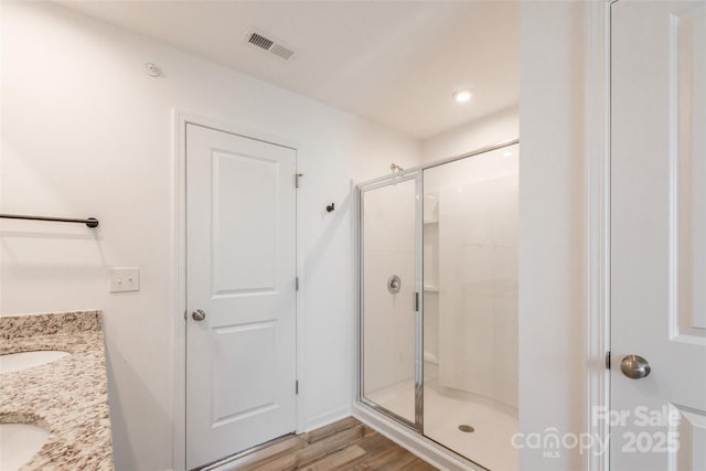 3073 Langhorne Ave SW, Concord, NC 28027 - full bathroom with a shower stall, wood finished floors, and double vanity