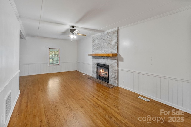956 Stony Point Rd, Kings Mountain, NC 28086 - unfurnished living room featuring crown molding, a fireplace, a ceiling fan, wood finished floors, and a wainscoted wall