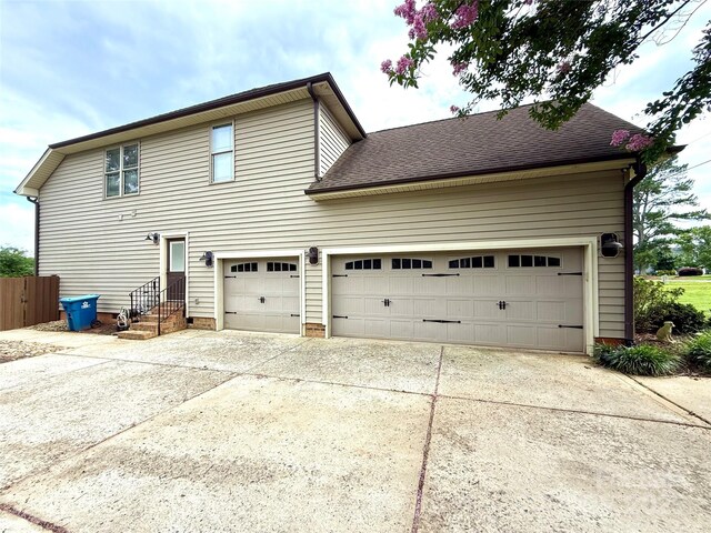 141 Weathers Creek Rd, Troutman, NC 28166 - rear view of property with driveway, a garage, and a shingled roof