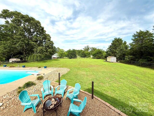141 Weathers Creek Rd, Troutman, NC 28166 - view of yard with a storage shed, a fire pit, a patio area, and view of wooded area