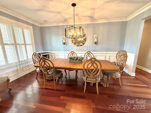 141 Weathers Creek Rd, Troutman, NC 28166 - dining area featuring a chandelier, wood finished floors, breakfast area, ornamental molding, and a decorative wall