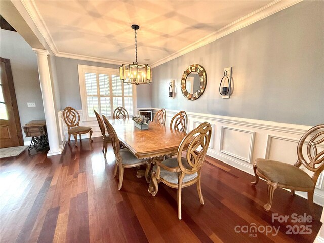 141 Weathers Creek Rd, Troutman, NC 28166 - dining space with decorative columns, dark wood finished floors, crown molding, a chandelier, and wainscoting