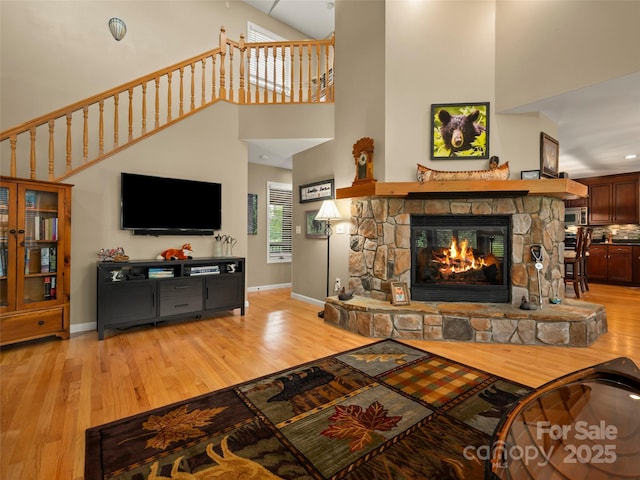 117 Eagles Crest Way, Lake Lure, NC 28746 - living room with a high ceiling, light wood finished floors, a stone fireplace, and baseboards