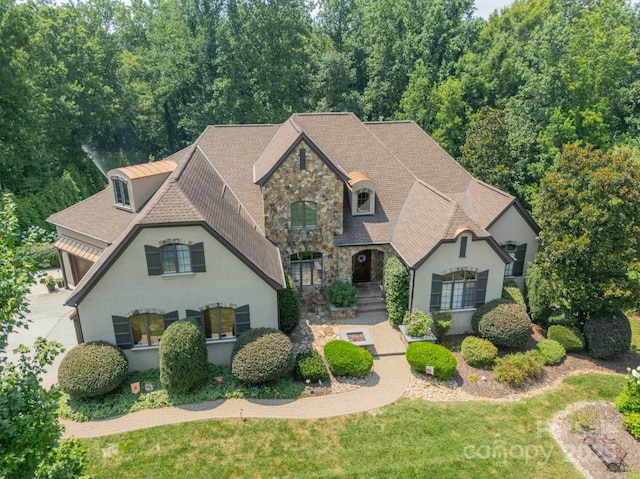 1032 Seminole Dr, Waxhaw, NC 28173 - french provincial home featuring stone siding, stucco siding, roof with shingles, and a front yard