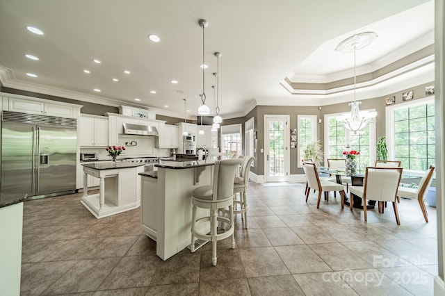 1032 Seminole Dr, Waxhaw, NC 28173 - kitchen with built in appliances, crown molding, a spacious island, healthy amount of natural light, and ventilation hood