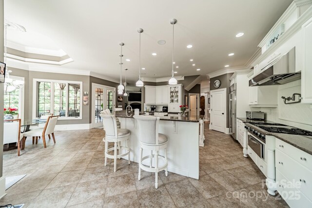 1032 Seminole Dr, Waxhaw, NC 28173 - kitchen with ornamental molding, a breakfast bar, a large island, recessed lighting, and glass insert cabinets