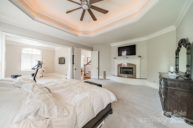 1032 Seminole Dr, Waxhaw, NC 28173 - carpeted bedroom featuring ornamental molding, a tray ceiling, a fireplace, and a ceiling fan