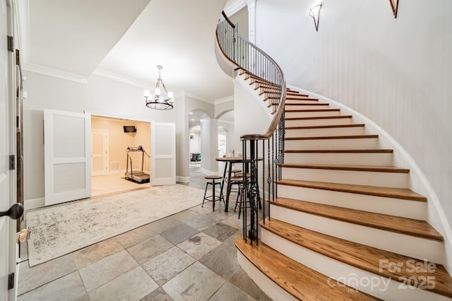 1032 Seminole Dr, Waxhaw, NC 28173 - foyer featuring arched walkways, stairs, crown molding, stone tile floors, and a chandelier