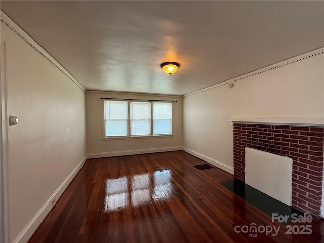 317 Heilig Ave, Salisbury, NC 28144 - unfurnished living room featuring baseboards, dark wood-style floors, ornamental molding, and a fireplace