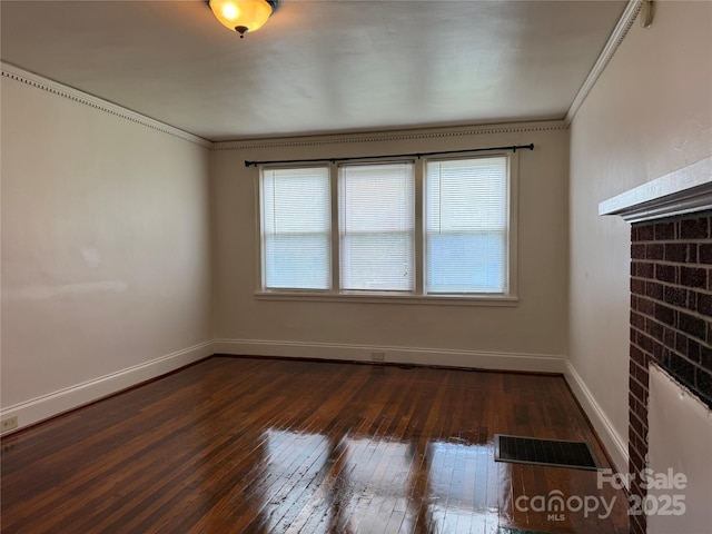 317 Heilig Ave, Salisbury, NC 28144 - unfurnished living room featuring dark wood finished floors, healthy amount of natural light, ornamental molding, a brick fireplace, and baseboards