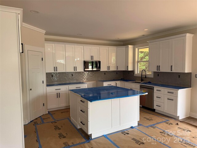 2589 Polo Ln, Maiden, NC 28650 - kitchen featuring stainless steel dishwasher, a sink, tasteful backsplash, white cabinets, and ornamental molding