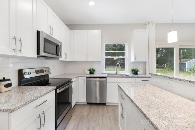 212 Queens Ct, Gastonia, NC 28052 - kitchen with appliances with stainless steel finishes, a sink, white cabinets, and light wood-style floors