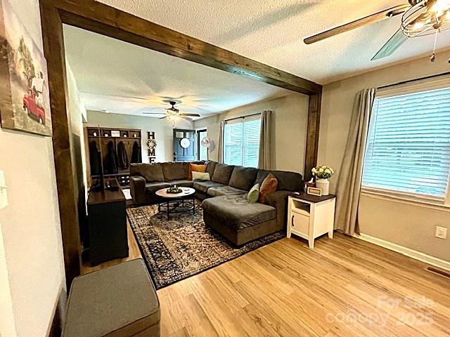 135 Michelle Dr, Ellenboro, NC 28040 - living area featuring a ceiling fan, a textured ceiling, light wood finished floors, beam ceiling, and baseboards