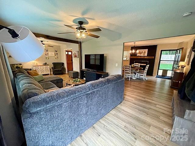 135 Michelle Dr, Ellenboro, NC 28040 - living room with wood finished floors, ceiling fan, a chandelier, and a textured ceiling