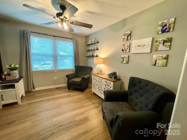 135 Michelle Dr, Ellenboro, NC 28040 - living area with ceiling fan, light wood-style floors, baseboards, and a textured ceiling
