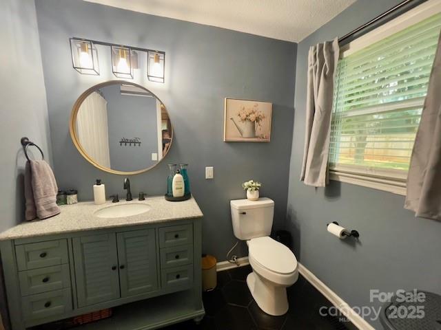 135 Michelle Dr, Ellenboro, NC 28040 - bathroom featuring toilet, vanity, baseboards, and tile patterned floors