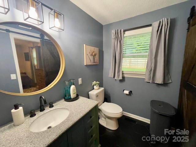 135 Michelle Dr, Ellenboro, NC 28040 - half bathroom with lofted ceiling, vanity, toilet, and baseboards