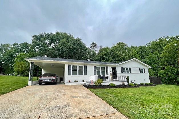 135 Michelle Dr, Ellenboro, NC 28040 - view of front facade with concrete driveway, a front yard, and a carport