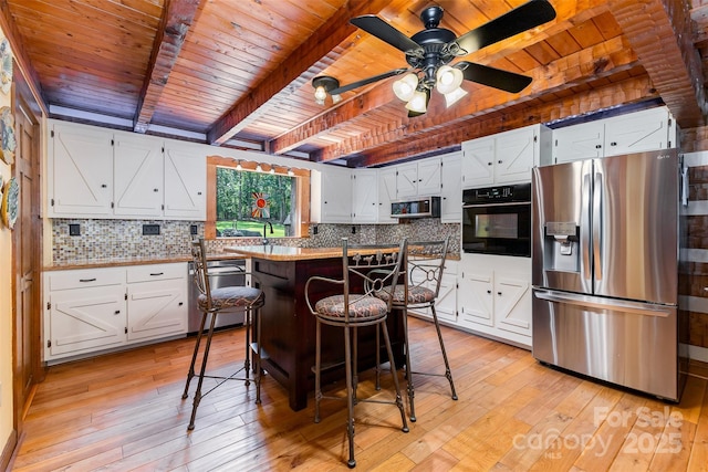 2709 Blythe Rd, Waxhaw, NC 28173 - kitchen featuring appliances with stainless steel finishes, wooden ceiling with exposed beams, light wood-style floors, and decorative backsplash
