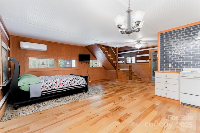 2709 Blythe Rd, Waxhaw, NC 28173 - bedroom featuring an AC wall unit, wood walls, light wood finished floors, and a chandelier