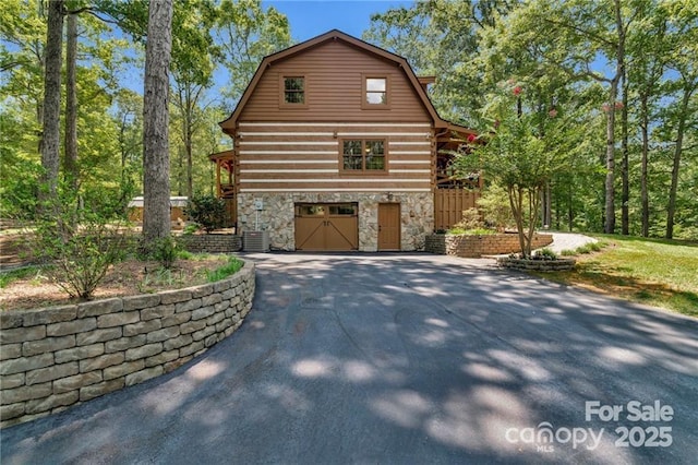 2709 Blythe Rd, Waxhaw, NC 28173 - view of side of property featuring stone siding, driveway, a gambrel roof, and a garage