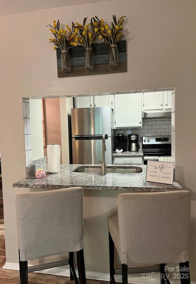 229 Windsor Point Rd Unit 6B, Columbia, SC 29223 - kitchen featuring exhaust hood, stainless steel appliances, a sink, stone counters, and a peninsula