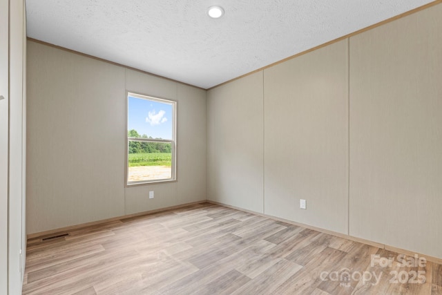 977 Myers Mill Rd, Olin, NC 28660 - unfurnished room featuring light wood finished floors, crown molding, and a textured ceiling