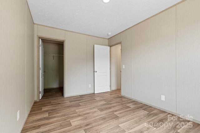 977 Myers Mill Rd, Olin, NC 28660 - unfurnished bedroom featuring light wood-style floors, a walk in closet, and a closet