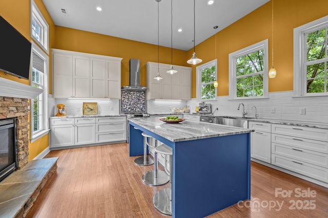 2009 Waterbury Ln, Waxhaw, NC 28173 - kitchen with wall chimney range hood, a kitchen island, white cabinets, and recessed lighting