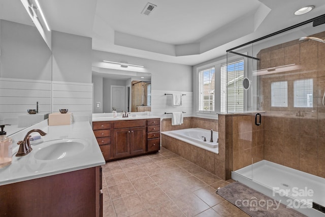 2009 Waterbury Ln, Waxhaw, NC 28173 - full bath featuring two vanities, a garden tub, a raised ceiling, and a shower stall