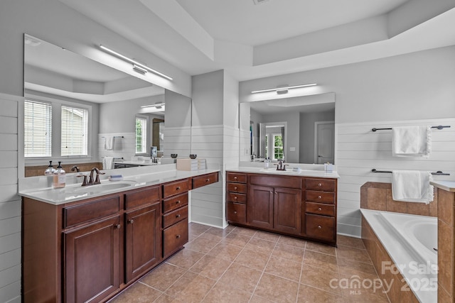 2009 Waterbury Ln, Waxhaw, NC 28173 - full bath with a raised ceiling, two vanities, a garden tub, and tile patterned flooring