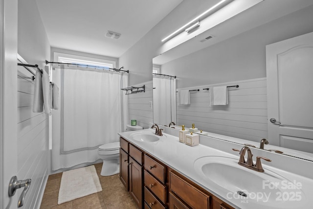 2009 Waterbury Ln, Waxhaw, NC 28173 - full bathroom with double vanity, shower / tub combo with curtain, a wainscoted wall, and tile patterned flooring