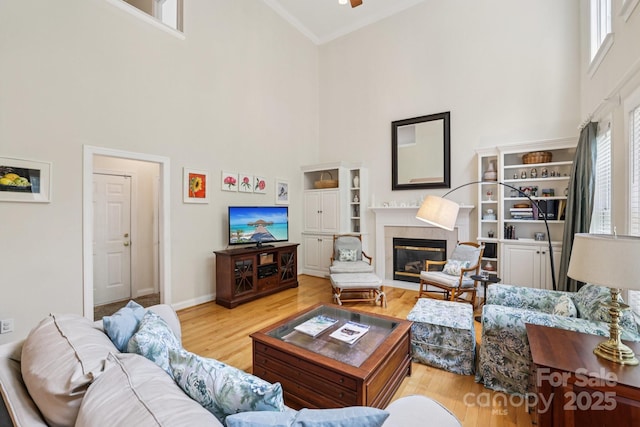 11103 Fountaingrove Dr, Charlotte, NC 28262 - living room with a towering ceiling, wood finished floors, a premium fireplace, ceiling fan, and baseboards