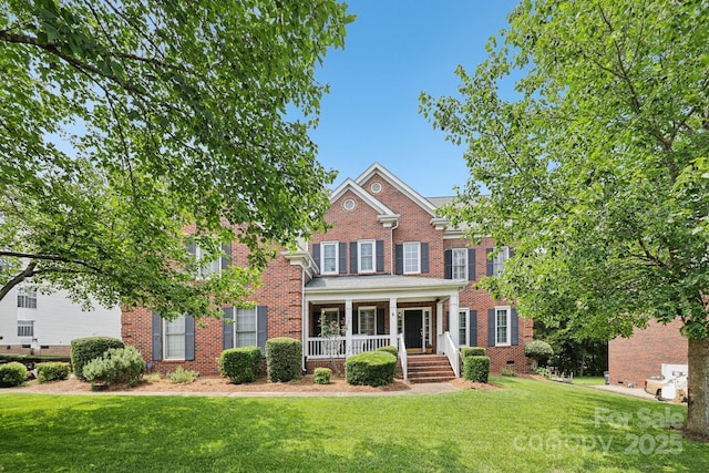 11103 Fountaingrove Dr, Charlotte, NC 28262 - view of front of house featuring covered porch, brick siding, and a front yard
