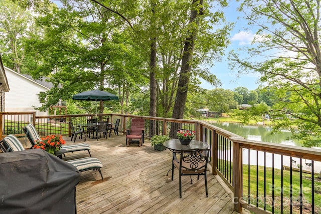 7232 Executive Cir, Denver, NC 28037 - wooden terrace featuring outdoor dining area, a water view, grilling area, and view of wooded area