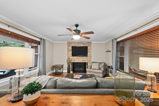306 Tremont Park Cir SE, Lenoir, NC 28645 - living area with a ceiling fan, ornamental molding, a stone fireplace, baseboards, and wood finished floors