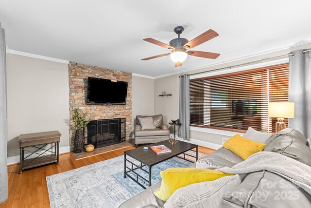 306 Tremont Park Cir SE, Lenoir, NC 28645 - living room featuring a ceiling fan, ornamental molding, wood finished floors, a fireplace, and baseboards
