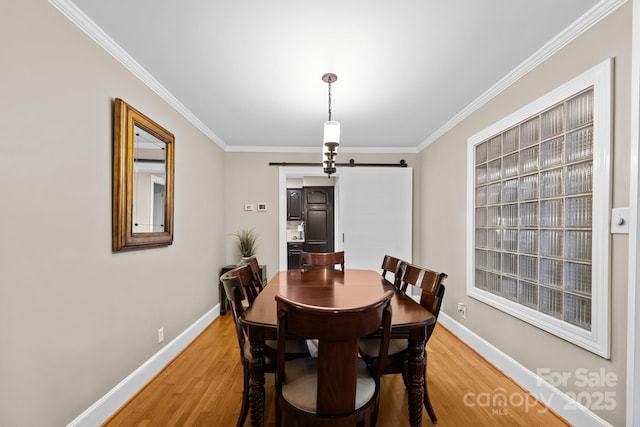 306 Tremont Park Cir SE, Lenoir, NC 28645 - dining space with a barn door, light wood finished floors, ornamental molding, and baseboards