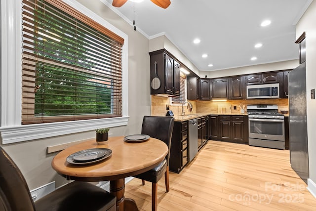 306 Tremont Park Cir SE, Lenoir, NC 28645 - kitchen with appliances with stainless steel finishes, a sink, ornamental molding, light wood-style flooring, and light stone counters