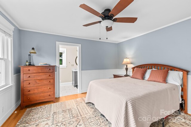 306 Tremont Park Cir SE, Lenoir, NC 28645 - bedroom featuring wood finished floors, wainscoting, multiple windows, crown molding, and ensuite bath