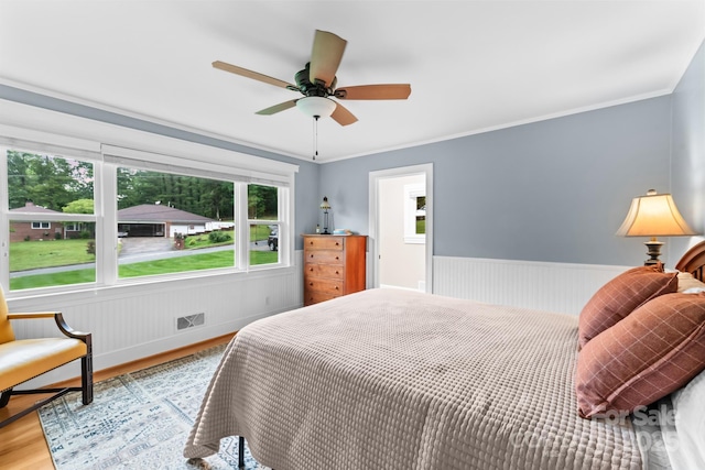 306 Tremont Park Cir SE, Lenoir, NC 28645 - bedroom with wood finished floors, wainscoting, crown molding, and a ceiling fan