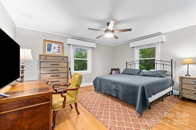 306 Tremont Park Cir SE, Lenoir, NC 28645 - bedroom featuring multiple windows, crown molding, wood finished floors, a ceiling fan, and baseboards