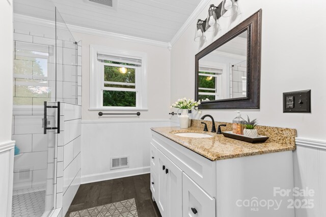 306 Tremont Park Cir SE, Lenoir, NC 28645 - bathroom with vanity, a shower stall, ornamental molding, wainscoting, and wood finished floors