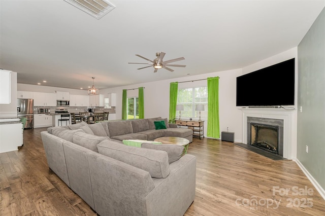711 Saddlebred Ln, Locust, NC 28097 - living area with a ceiling fan, a fireplace with flush hearth, light wood-style flooring, and recessed lighting