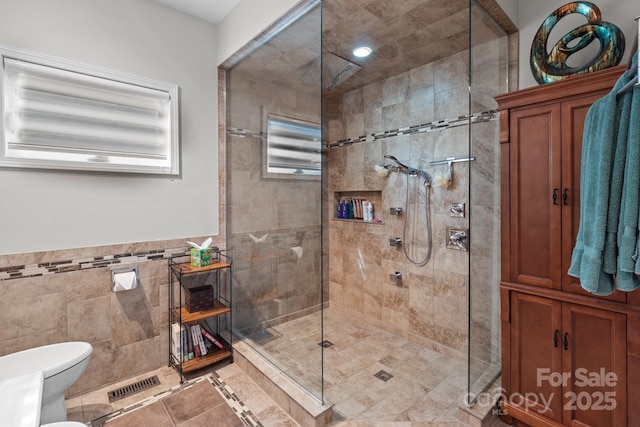 1525 Valhalla Dr, Denver, NC 28037 - bathroom featuring a walk in shower, tile walls, toilet, tile patterned floors, and a wainscoted wall